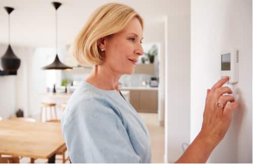 chauffagiste paris - femme réglant son thermostat