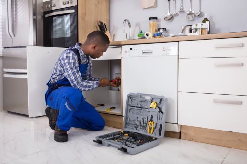 plombier chavenay - un plombier installe les appareils sanitaires d'une cuisine