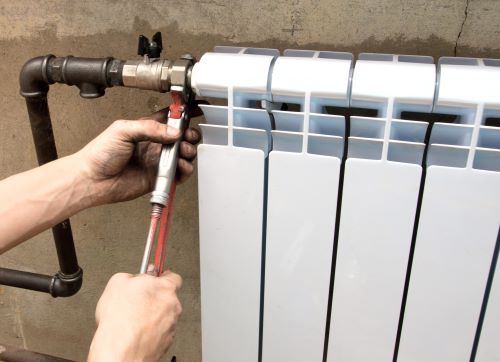 plombier Aubervilliers - un plombier installe un radiateur