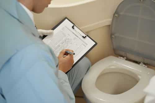 plombier Créteil - un artisan inspecte des toilettes