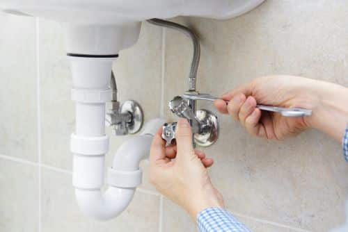 plombier Le Blanc Mesnil - un artisan installe un flexible dans une salle de bains