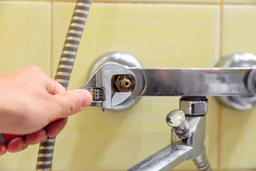 Plombier Laval - Un plombier remplace une valve d'un robinet d'eau.