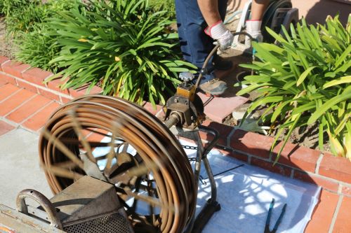 plombier Gagny - un artisan débouche une canalisation extérieure avec un furet électrique