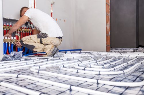 plombier Meudon - un artisan installe un plancher chauffant