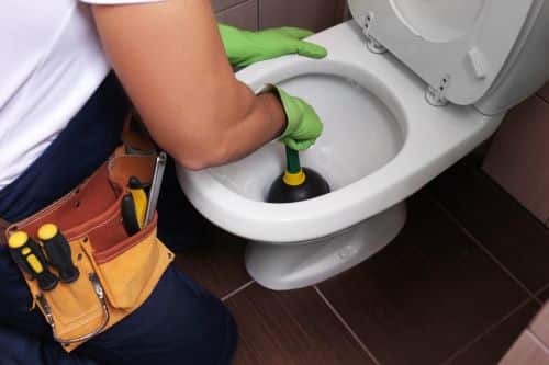 plombier Noisy-le-Sec - un artisan débouche des toilettes avec une ventouse