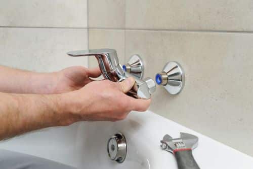 plombier Saint-Ouen - un artisan installe un robinet de salle de bains