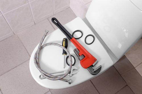 plombier Villepinte- des outils de plomberie sur la cuvette des toilettes