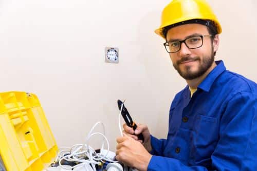Électricien Annecy - Un artisan s'apprête à installer une prise électrique.