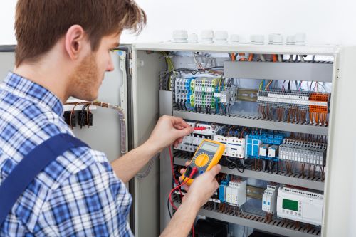 Électricien Le Havre - Un technicien teste une résistance sur un tableau électrique.