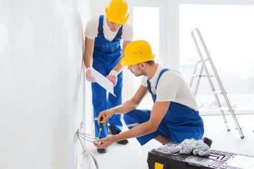 Électricien Le Havre - Deux électriciens installent un circuit électrique dans un nouvel appartement.