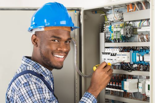 Électricien Nancy - Un artisan effectue des modifications sur un tableau électrique.