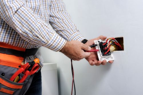 Électricien Orléans - Un électricien installe une prise électrique.