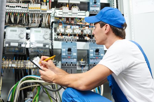 Électricien Strasbourg - Un électricien inspecte l'équipement d'un compteur électrique.