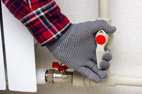 Plombier Blois - Un plombier ferme un circuit d'eau de radiateur.