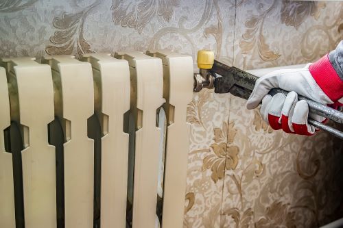 Plombier Boulogne-sur-Mer - Un artisan répare un radiateur.