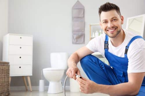 Plombier Montfermeil - Un plombier travaille sur des toilettes.