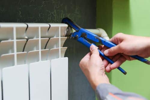 Plombier Neuilly-sur-Marne - Un artisan remplace les pièces d'un radiateur.