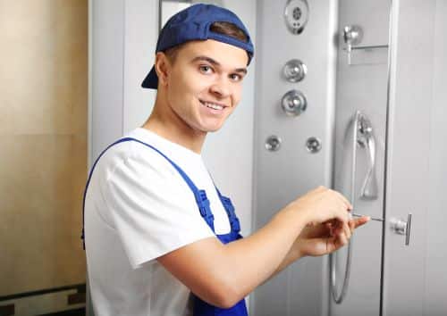 plombier Bois-Colombes - un homme installe une cabine de douche