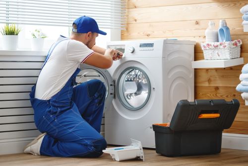 plombier Clichy-sous-Bois - Un artisan répare un lave linge.