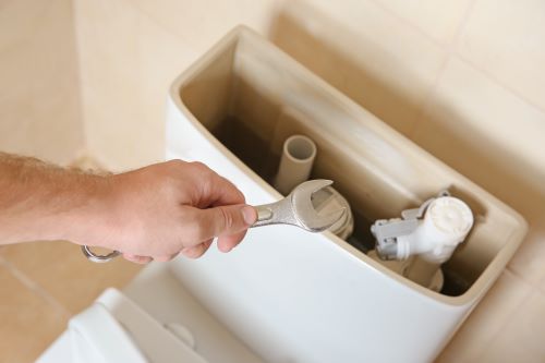 plombier La Garenne-Colombes - un hommeinstalle une chasse d'eau