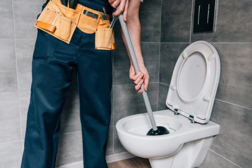 plombier Thiais - un artisan débouche des toilettes avec une ventouse