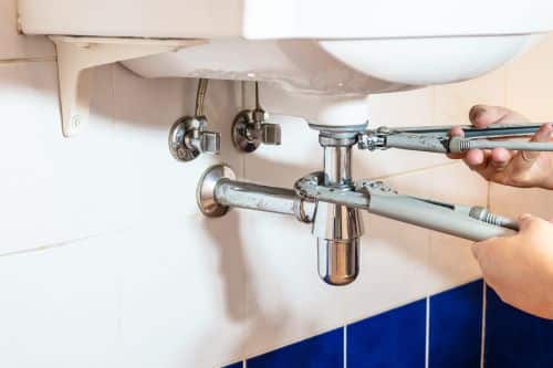 plombier Yerres - un homme intervient sur le siphon d'un lavabo