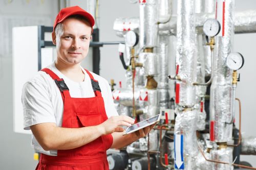 Chauffagiste Angers - Un chauffagiste travaille sur un système de chauffage.