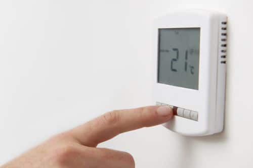 Chauffagiste Aubervilliers - Un homme règle la température de son thermostat