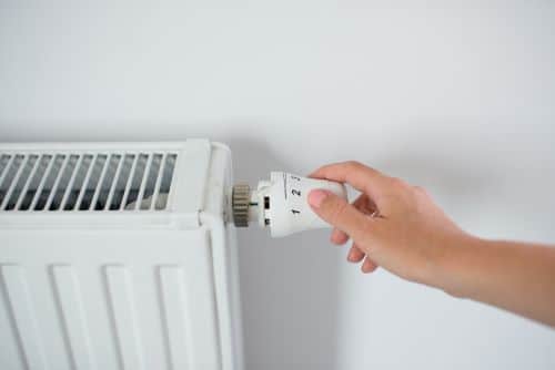 Chauffagiste Besançon - Une femme règle un radiateur.