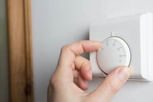 Chauffagiste Dunkerque - Un homme règle la température de son thermostat