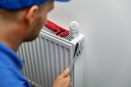 Chauffagiste Nîmes - Un chauffagiste répare un radiateur