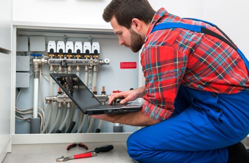 Chauffagiste Rennes - Un chauffagiste fait des vérifications sur un système de chauffage.