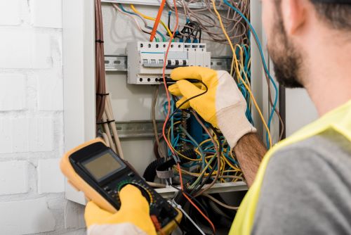 Électricien Antibes - Un électricien fait des tests sur un tableau électrique.