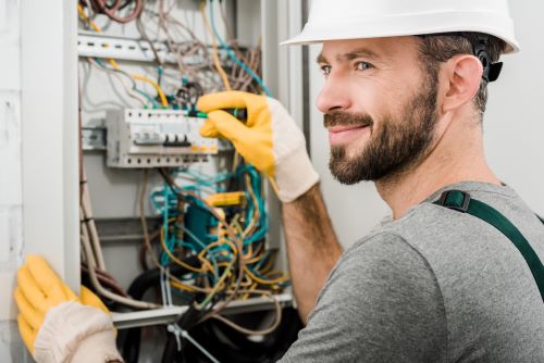 Électricien Bourges - Un artisan répare un tableau électrique.