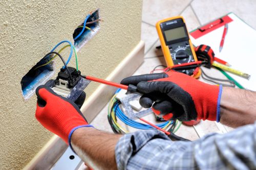 Électricien Brest - Un électricien installe des prises électriques.