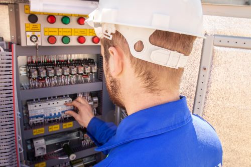 Électricien Calais - Un artisan fait des vérifications sur un tableau électrique.