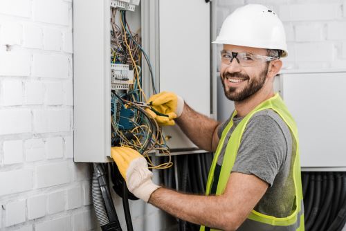 Électricien Calais - Un électricien répare un tableau électrique.