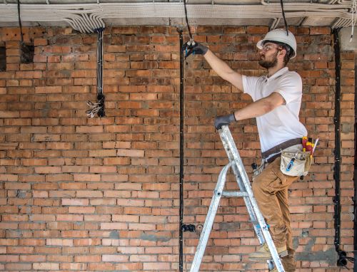 Électricien Clichy - Un artisan installe un nouveau réseau électrique dans une maison.