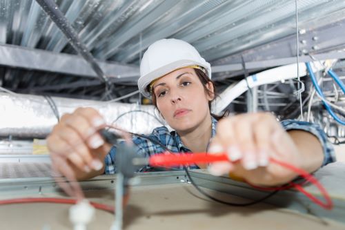 Électricien Colombes - Une électricienne effectue une installation.