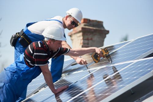 Électricien Valence - Deux artisans installent des panneaux solaires.