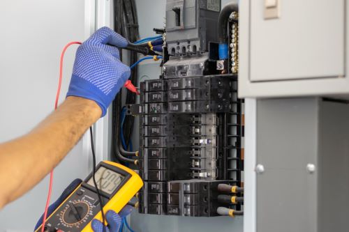 Électricien Valence - Un artisan mesure la tension d'un tableau électrique.