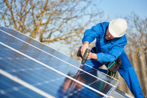 Électricien Pessac - Un électricien installe des panneaux solaires.