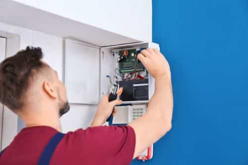 Électricien Tours - Un électricien installe une alarme.