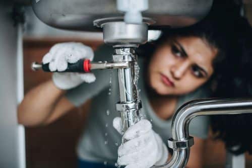 Plombier Launaguet - Un plombier répare une fuite d'eau sous un évier