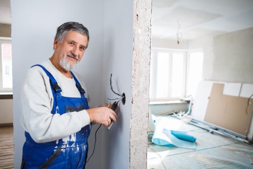 électricien Maisons-Alfort - un artisan travaille sur l'installation électrique d'une nouvelle maison