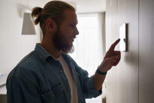 Chauffagiste Blois - Un homme règle son chauffage dans une maison.