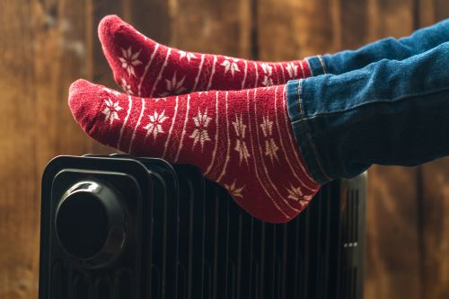 Chauffagiste Bobigny - Une femme a les pieds posé sur un radiateur