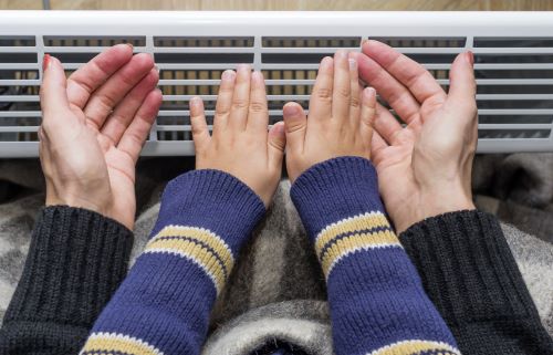 Chauffagiste Épinay-sur-Seine - Une femme et un enfant se réchauffe les mains près d'un chauffage
