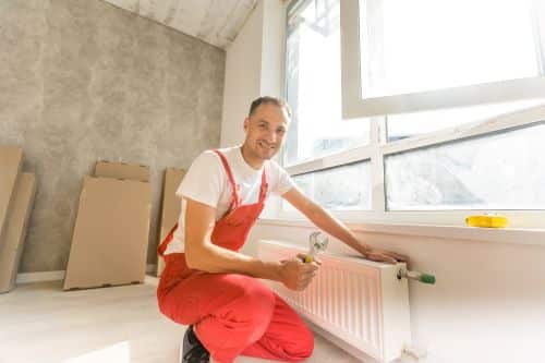 Chauffagiste Montauban - Un chauffagiste installe un radiateur au mur