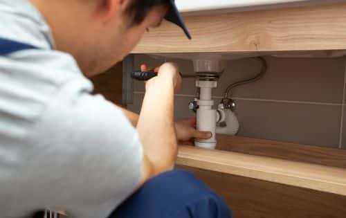 Plombier Carry-le-Rouet - Un plombier installe un siphon dans une salle de bain